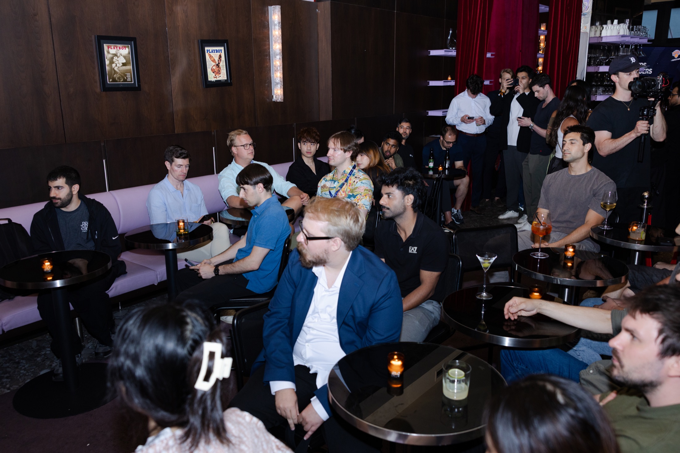 Guests seated around candlelit tables in the lounge at the New York event
