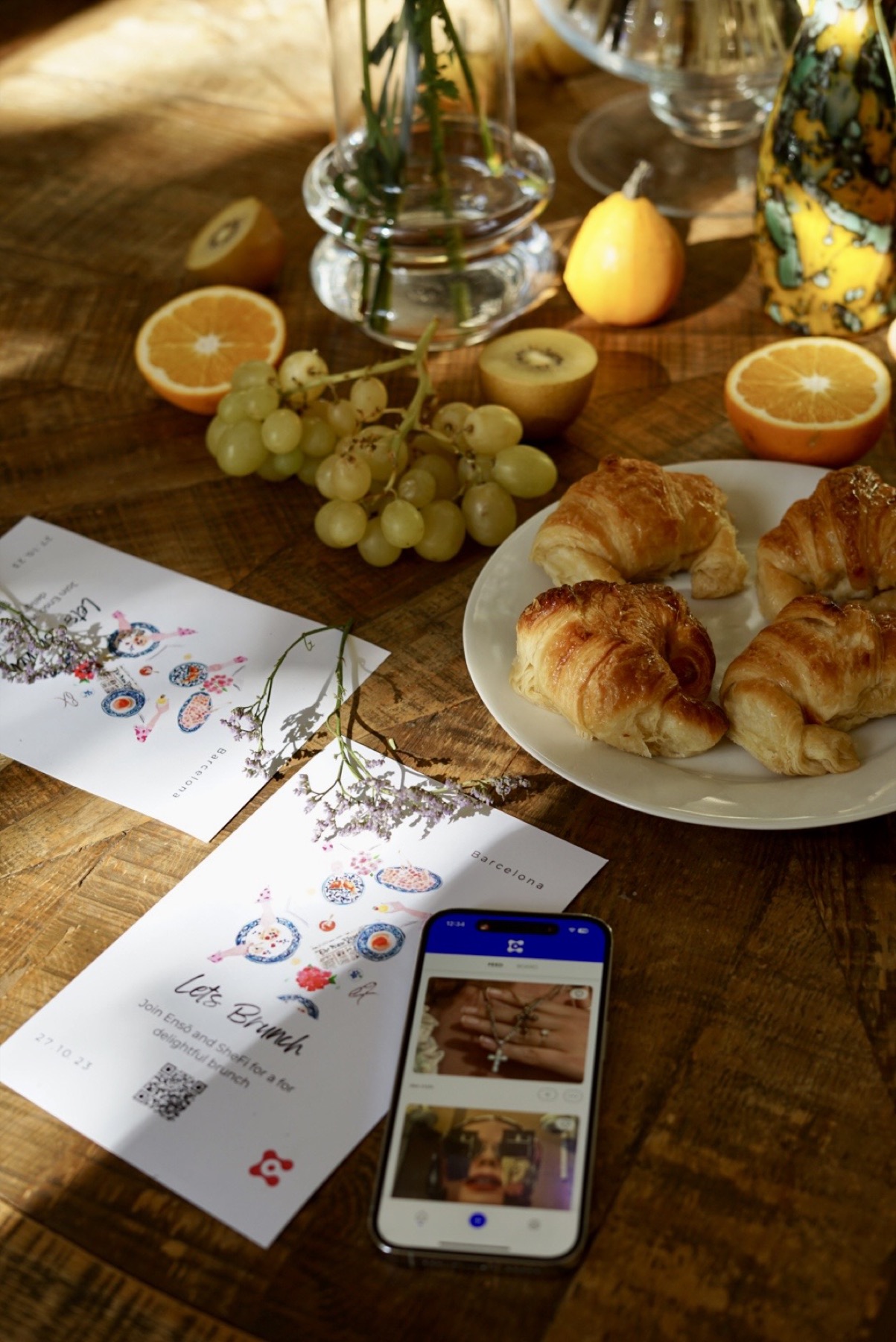 Barcelona brunch table with pastries, citrus, flowers, and phone display