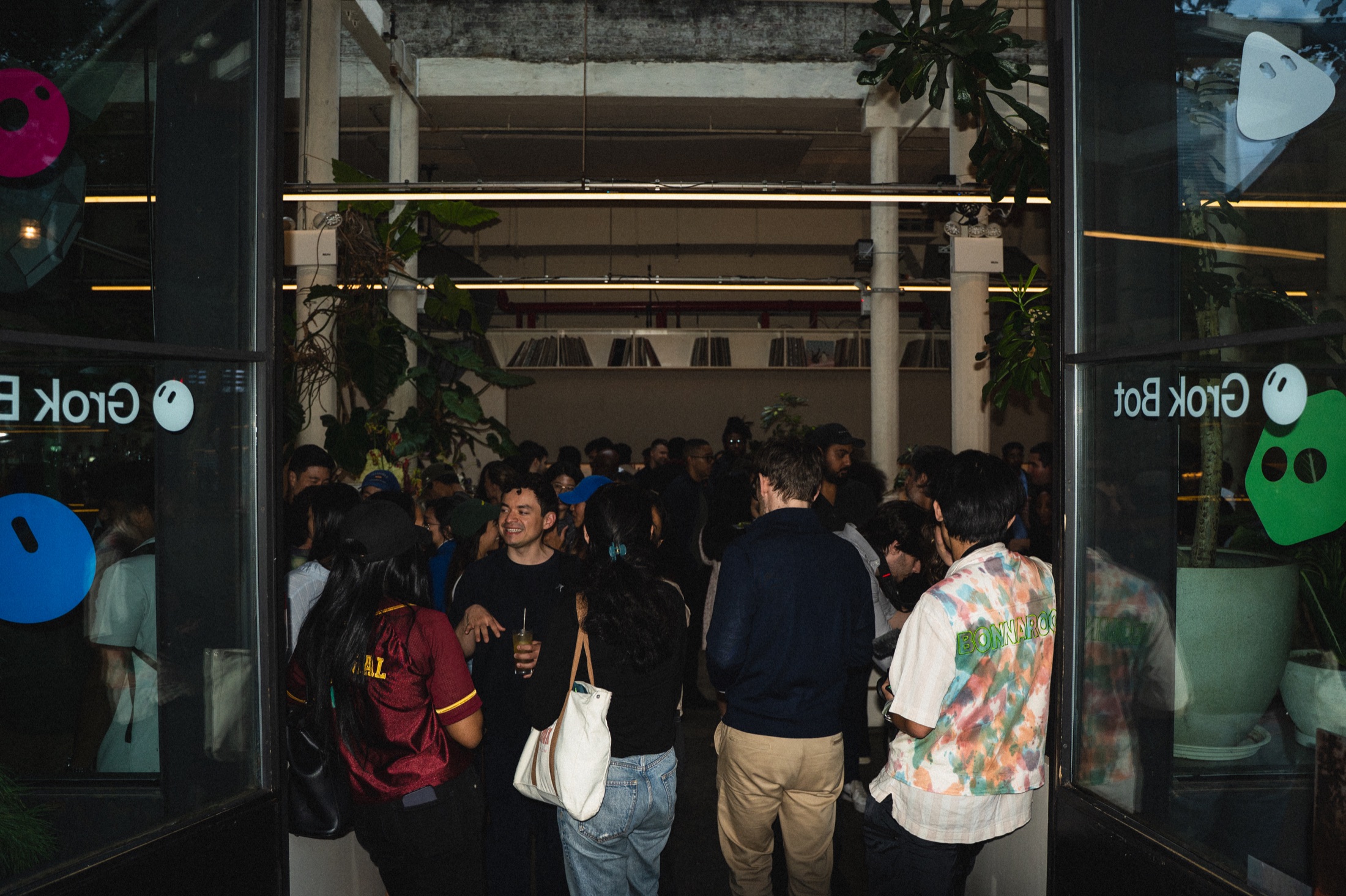 Guests gathered inside the New York venue, framed by Grok Bot-branded glass doors