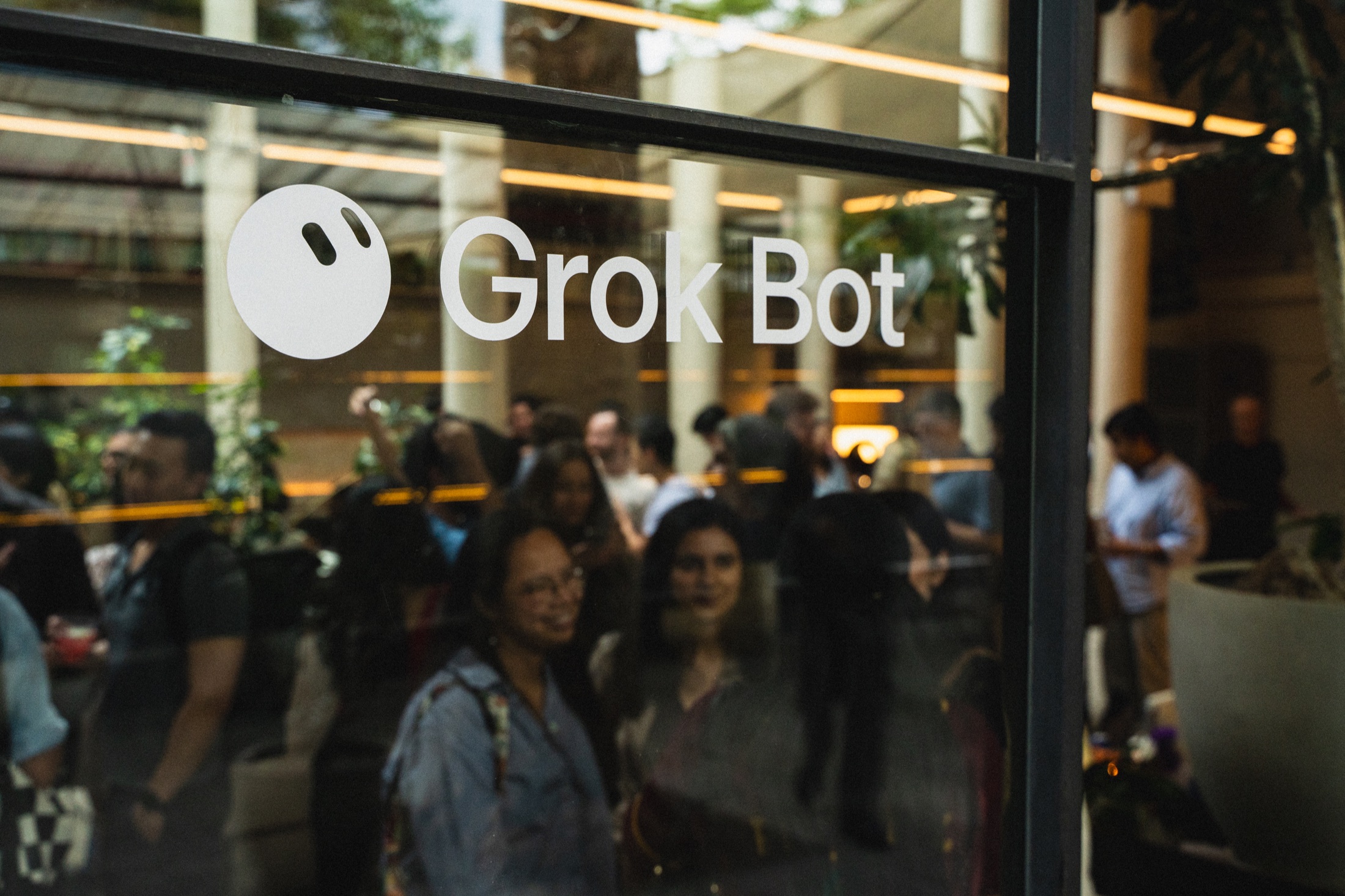 White Grok Bot branding on the New York venue window with guests inside