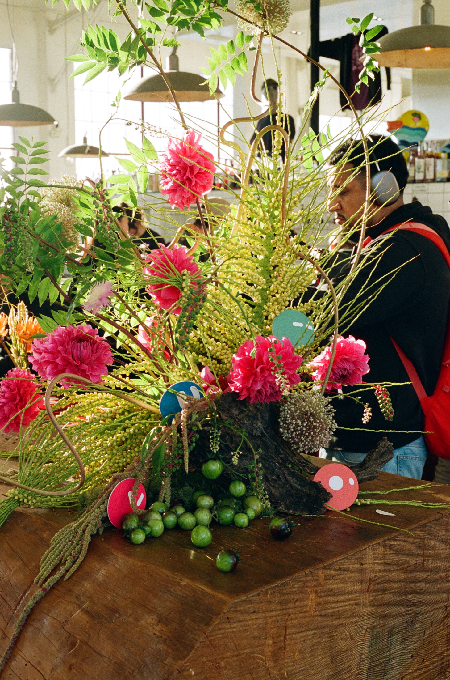 Pink flowers, greenery and colorful Grok Bot decorations arranged on a wooden table