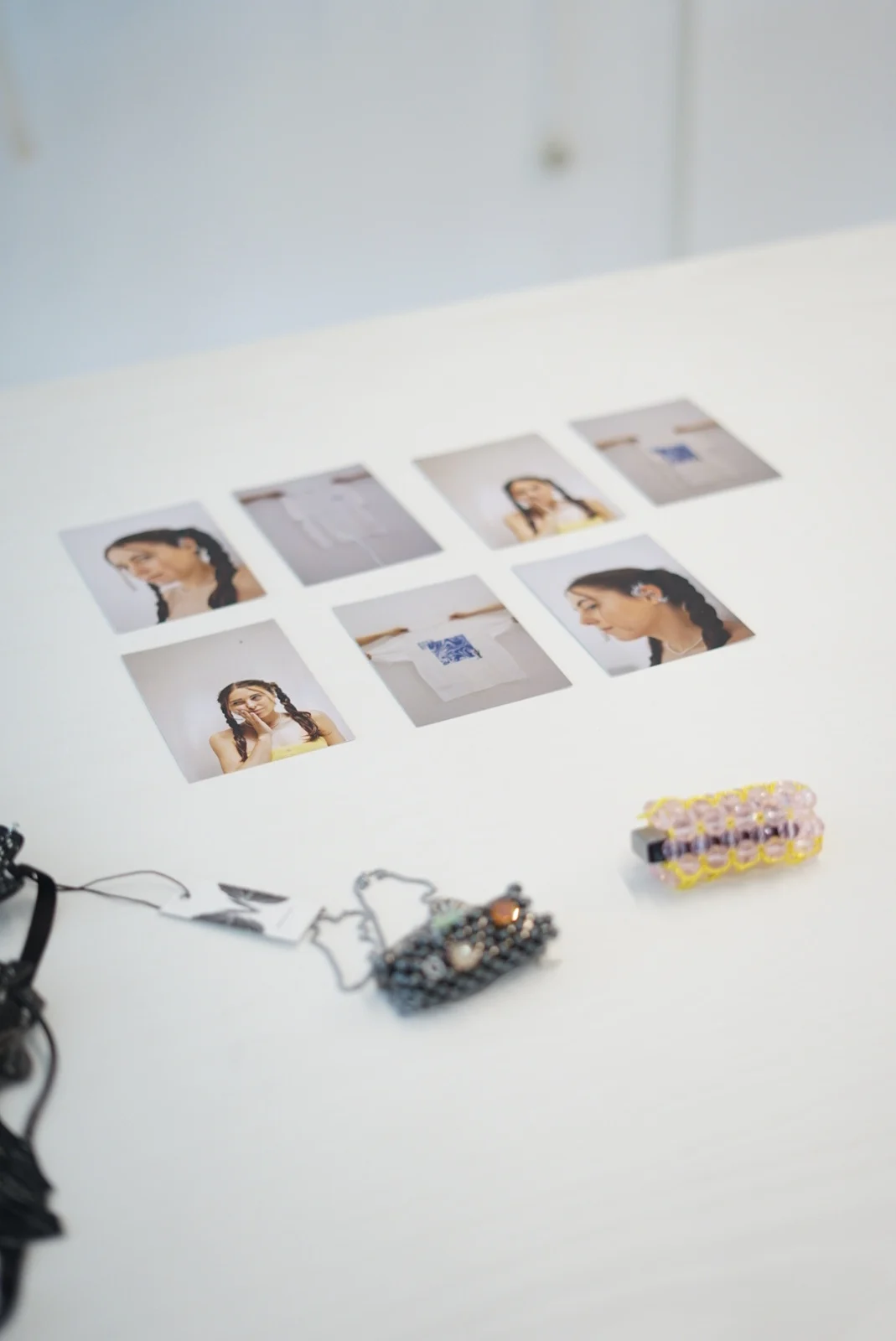 Jewellery and printed photographs arranged on a white display table