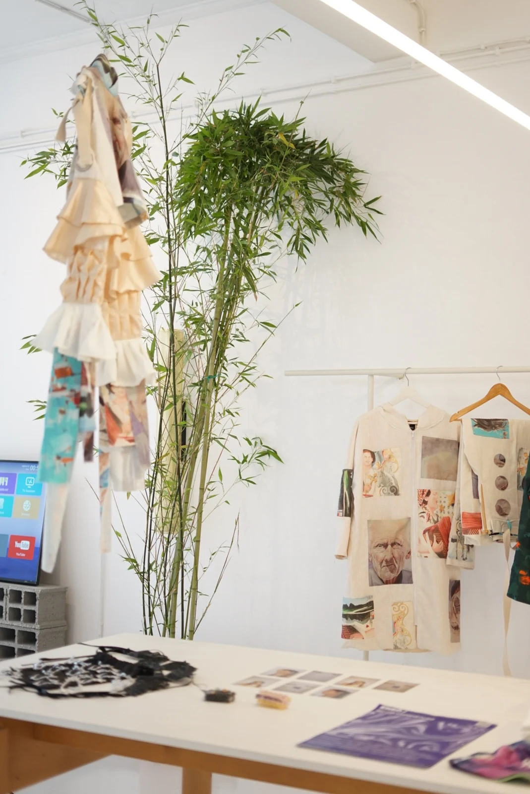 Printed garments, accessories, and photographs displayed in the Lisbon exhibition space