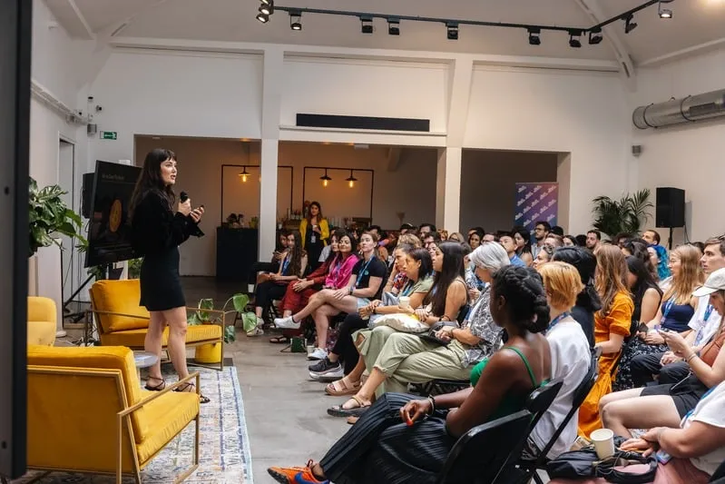 A speaker addressing seated guests at a SheFi Summit