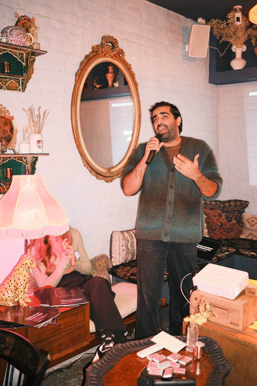 A speaker giving a pitch with a microphone in the speakeasy