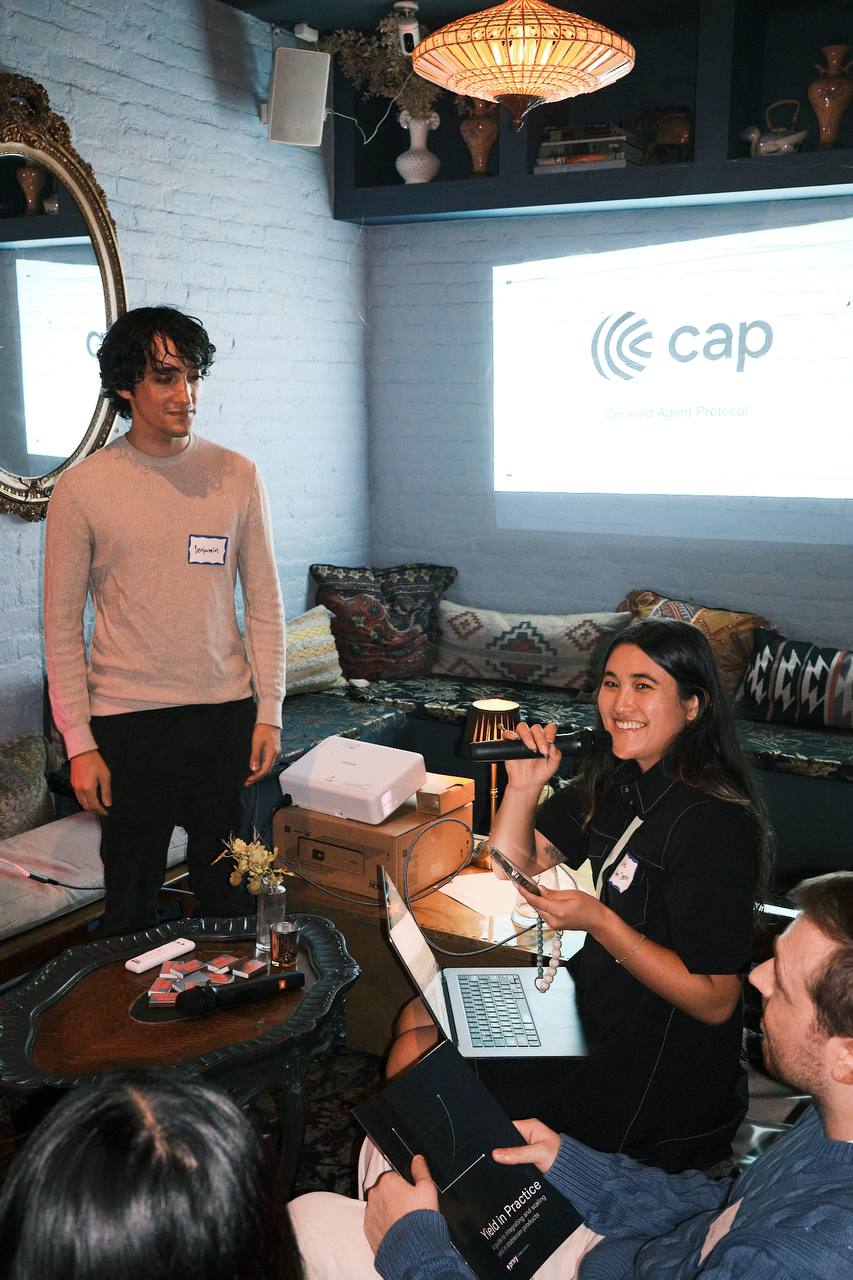A presenter and host beside a projected slide during the stablecoin pitches